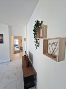 einen Flur mit einer weißen Wand und einer Holzbank in der Unterkunft Apartment SweetDreams in Bremerhaven