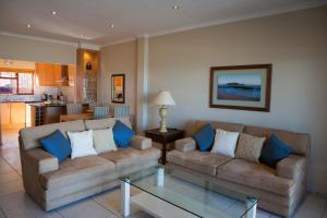 a living room with two couches and a table at Summer Place Gordons Bay in Gordonʼs Bay