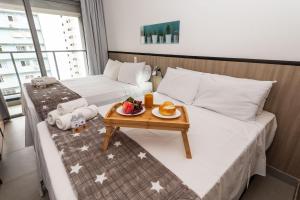 a hotel room with two beds with a tray of food on it at VS11 Studio Moderno Próximo ao Allianz Parque in Sao Paulo