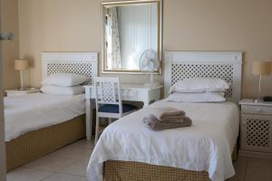 a bedroom with two beds and a mirror and a desk at Summer Place Gordons Bay in Gordonʼs Bay