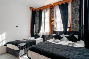 2 Betten in einem Zimmer mit Fenstern in der Unterkunft BÜTÜNOĞLU PANSİYON in Antalya