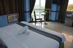 a bedroom with a bed with a chair and a window at ALU Hotel Davao in Davao City