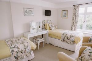 a bedroom with a bed and a desk and chairs at Leygreen Farmhouse in Beaulieu
