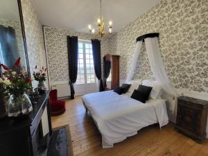 una camera con un letto bianco a baldacchino di Château Fédora a Marcilloles