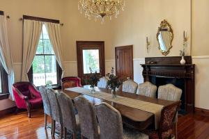 comedor con mesa, sillas y lámpara de araña en Victorian mini mansion near Lake Greenwood, en Cross Hill