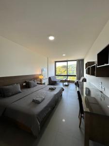 um quarto com uma cama grande e uma janela grande em Grey escape apartments em Qalḩāt