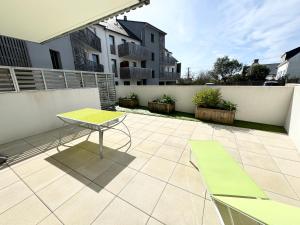 un patio con una mesa y una valla en Bel appartement T3 de standing – proche de la mer, en Plouharnel