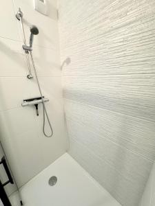 baño con ducha y puerta de cristal en Bel appartement T3 de standing – proche de la mer, en Plouharnel