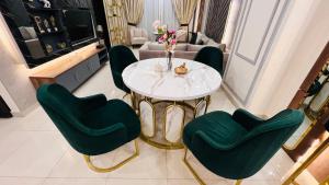 a living room with a table and green chairs at Sky Heights Executive Apartments Facing Centaurus Mall Islamabad in Islamabad