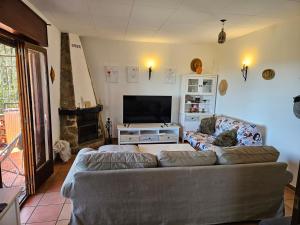 a living room with a couch and a flat screen tv at Montagne vue panoramique sur mer in Pals