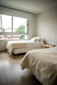 sypialnia z 2 łóżkami i dużym oknem w obiekcie Carilo Vista w mieście Carilo