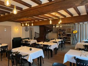 a dining room with white tables and black chairs at Restaurant Hotel Logis Chez Sophie in Briouze