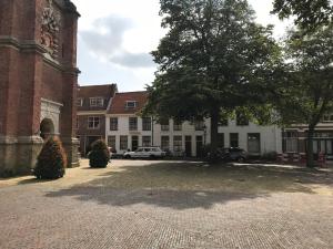 um pátio em frente a um edifício com uma árvore em the Sin Suite em Haarlem