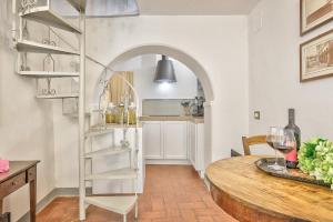 een keuken en eetkamer met een tafel en een ladder bij La Bomboniera - Together in Tuscany in Cortona