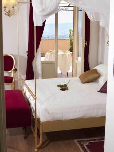una camera con letto a baldacchino e vista su un tavolo di Giotto Hotel & Spa ad Assisi