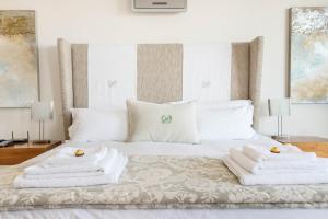 Un dormitorio con una cama blanca con toallas. en 74 on Marine, en Hermanus