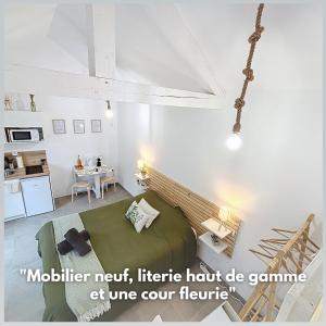 a living room with a bed and a table at Le Jardin des Plantes Rouen Studios et F2 au calmes, Terrasse, stationnement gratuit in Rouen