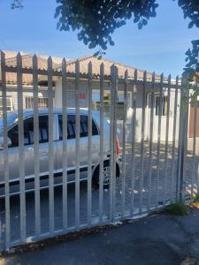 a white fence with a truck behind it at Ludinz guest house in Cape Town