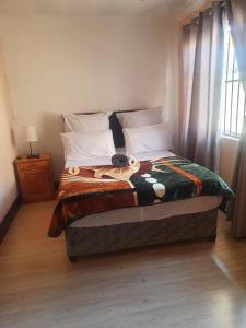 a bedroom with a bed with a stuffed animal on it at Ludinz guest house in Cape Town