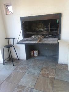 a fireplace in a room with a chair and a table at Ludinz guest house in Cape Town