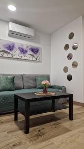 馬德里的住宿－Almendrales，客厅配有绿色沙发和桌子