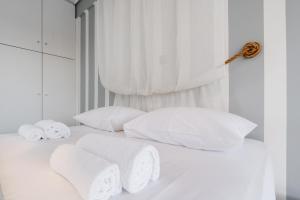 een wit bed met handdoeken en kussens erop bij AcroLofts M62 with Playground in Athene