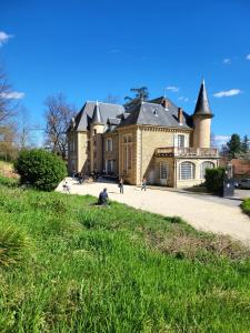 ein großes Haus mit Leuten, die davor herumlaufen in der Unterkunft Château Fédora in Marcilloles