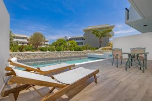 un patio con mesa y sillas junto a una piscina en Virginia Family Resort en Kallithea Rhodes