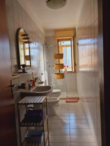 La salle de bains est pourvue d'un lavabo, de toilettes et d'une fenêtre. dans l'établissement Lorenzo Guest Suite - Cantieri culturali- Garage privato al coperto gratuito, à Palerme