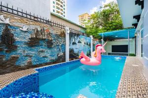 a swimming pool with a pink inflatablevisor in front of a building at KN3 Holiday Villa in Ho Chi Minh City