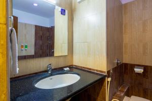 a bathroom with a sink and a mirror at Blue Bliss Hotel By PPH Living in Bangalore