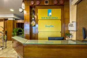 班加羅爾的住宿－Blue Bliss Hotel By PPH Living，大堂黄色墙上的蓝色粉尘球标