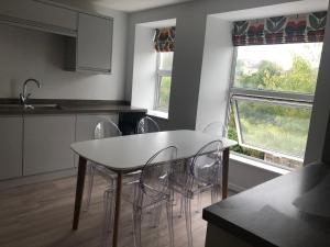 ファルマスにあるArmyn House Apartments, Your Coastal Escape in Falmouthのキッチン(白いテーブル、椅子付)