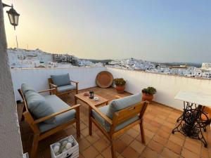 d'un balcon avec des chaises et une table offrant une vue. dans l'établissement Casa Cebollino & Zarabanda, à Vejer de la Frontera