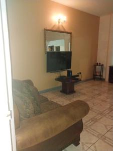 een woonkamer met een bank en een spiegel bij Jus4U-1 The Home Away From Home Villa in Ocho Rios
