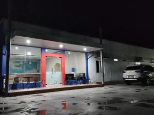 un estacionamiento con un coche estacionado frente a un edificio en H. V Hotel Bandara Gorontalo en Bongomeon