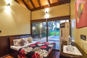 a bedroom with a bed and a large window at EKO STAY- BALI VILLA in Alibaug
