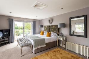 a bedroom with a bed and a mirror and a television at Harelands in Aldbrough
