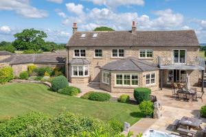 an aerial view of a large stone house with a patio at Harelands in Aldbrough