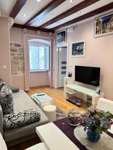 sala de estar con sofá y TV en Apartment Maris, en Dubrovnik
