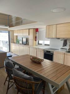 eine Küche mit einem Holztisch und einigen Stühlen in der Unterkunft Mellieha Bay Seafront 1bed Penthouse in Mellieħa