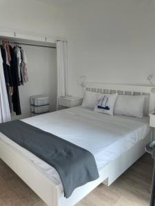 ein Schlafzimmer mit einem großen weißen Bett und einem Schrank in der Unterkunft Mellieha Bay Seafront 1bed Penthouse in Mellieħa