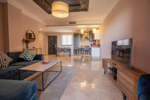 a living room with a couch and a tv at Oliva Hotel Condominium Marrakech in Marrakesh