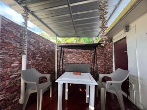 una mesa y sillas en un patio con una pared de ladrillo en Casa espaciosa con Jacuzzi, área sur PR, en Juana Díaz