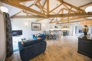 a living room with wooden ceilings and a blue couch at Kingfisher in Forcett