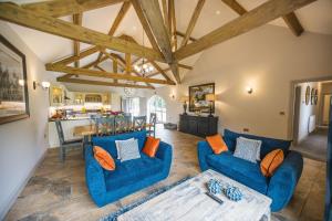 a living room with two blue couches and a kitchen at Kingfisher in Forcett