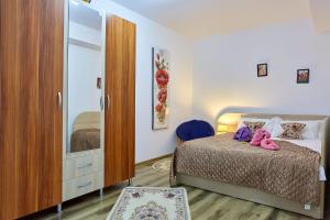 a bedroom with a bed and a dresser at Elite Mamaia Nord in Năvodari