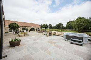 a large patio with a hot tub in a yard at Kingfisher in Forcett