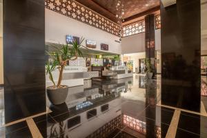 a lobby with a potted plant in the middle at Oliva Hotel Condominium Marrakech in Marrakesh