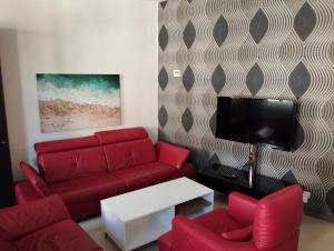 a living room with a red couch and a tv at Stadtblick 1 Monteuersfreud in Eisenberg